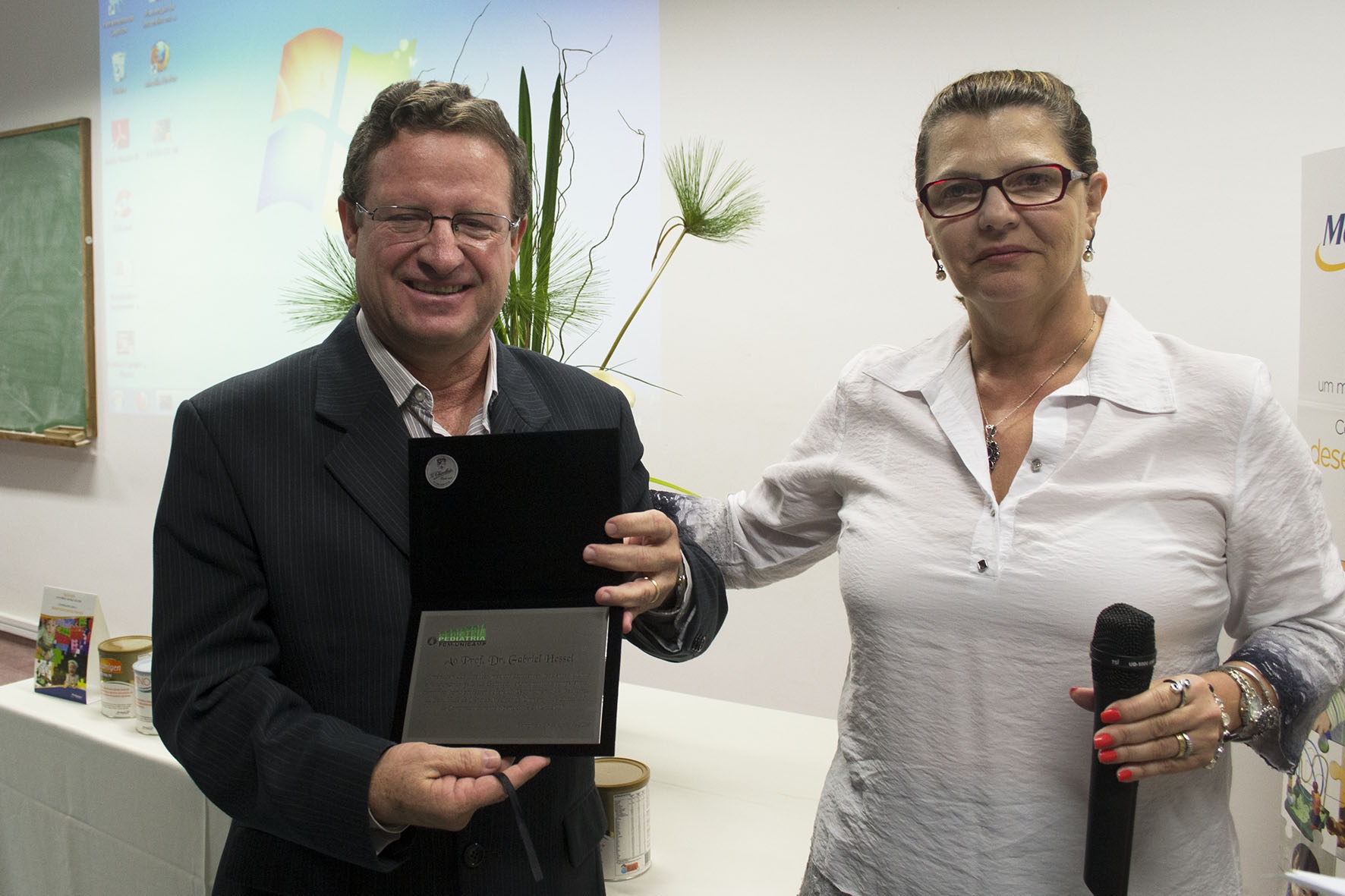 Gabriel Hessel recebe placa comemorativa das mãos da diretora associada da FCM, Rosa Inês Costa Pereira. Foto: Marcelo Oliveira. CADCC-FCM/Unicamp